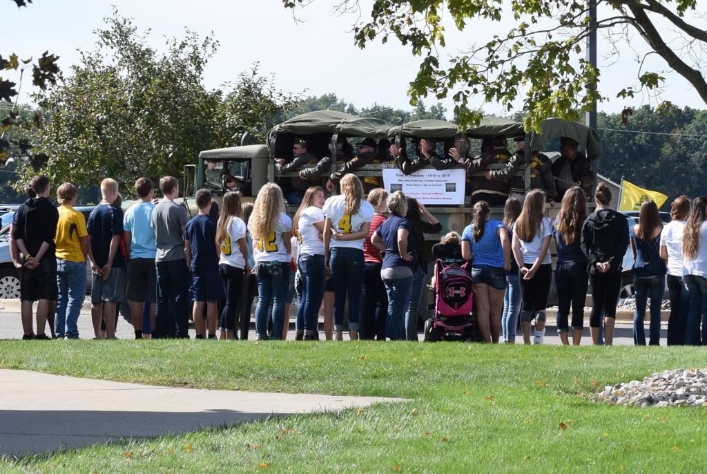 Students watch Michigan Vietnam Memoral Wall pass through the parking lot.